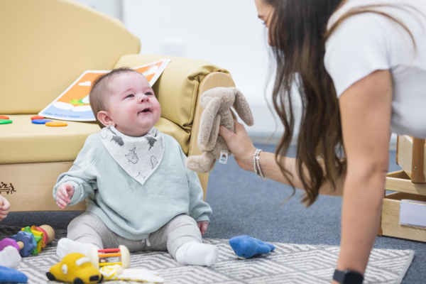 Nursery Practitioner won floor playing with baby